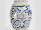a blue and yellow vase with a name on it