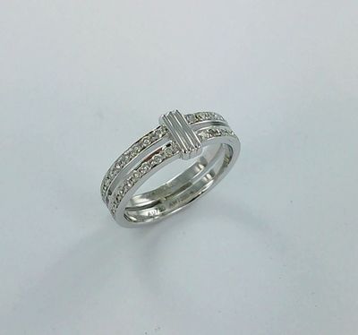 une bague en or blanc ornée d'une croix sur l'anneau
