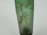 a green glass vase with a silver lid on a white surface