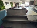tables and benches in a restaurant with a wall of plants on the wall