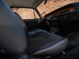 the interior of a classic car with a brick wall in the background