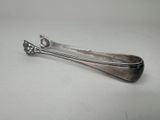 une cuillère en argent posée sur une table, sur fond blanc