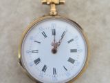 a gold pocket watch with roman numerals on it