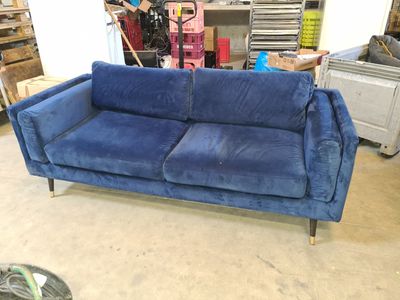 a blue couch that is sitting in the middle of a room