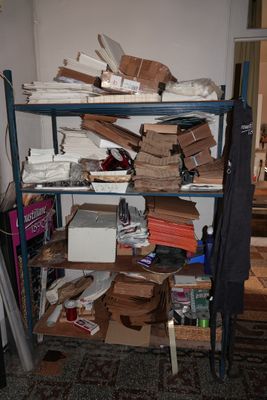une étagère remplie de cartons et d'autres objets dans une pièce