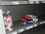 many bottles of soda on the shelves in the store