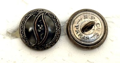 paire de boutons anciens au motif ouvragé sur fond blanc