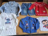 several children ' s clothing are displayed on a table in a cardboard box