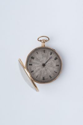 une montre de poche en or avec des chiffres romains sur le cadran