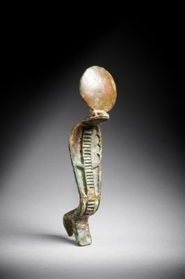 an egyptian bronze figurine of a man with a pearl on his head