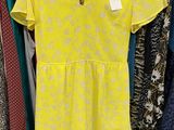 a yellow dress hanging on a rack in a clothing store