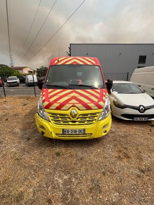 une camionnette jaune et rouge garée à côté d'une voiture blanche