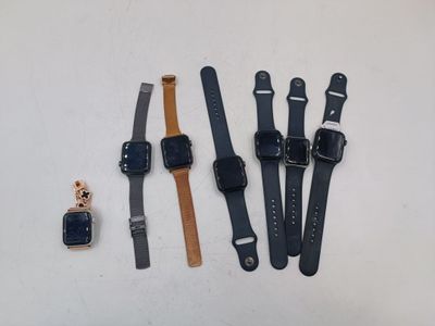 Quatre modèles de montres différents sont disposés sur une surface blanche