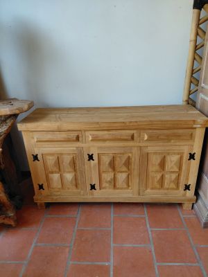 a wooden cabinet sitting on the floor next to a chair