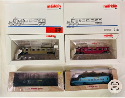 trois trains miniatures dans leurs boîtes, empilés les uns sur les autres