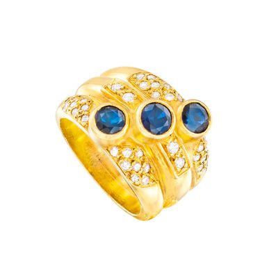 gros plan d'une bague en or avec saphirs et diamants