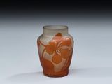 un vase en verre orné d'une fleur, posé sur une surface blanche