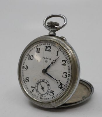 a silver pocket watch sitting on top of a white table