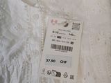 the label on a white shirt is attached to a hanger