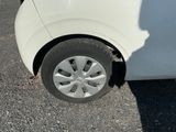 a small white car with a flat tire on the street