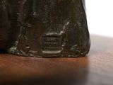 a bronze statue of a cat sitting on a table