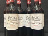quatre bouteilles de vin sont alignées sur une surface noire