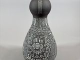 a black and white vase with a pattern on it