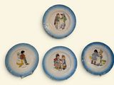 quatre assiettes bleues et blanches ornées de personnages de dessins animés, posées sur un fond blanc