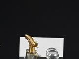 bottles of perfume on a table next to a clock and a mirror