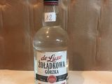 une bouteille de vodka vide posée sur une table devant un mur