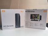 des cartons posés sur une table sur laquelle se trouvent une télévision et un ordinateur portable