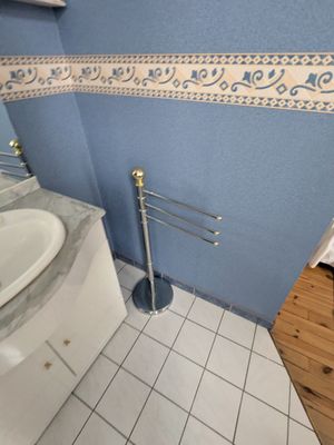 une salle de bains avec un mur bleu et un lavabo blanc