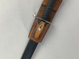 a close up of a knife with a wooden handle on a white surface