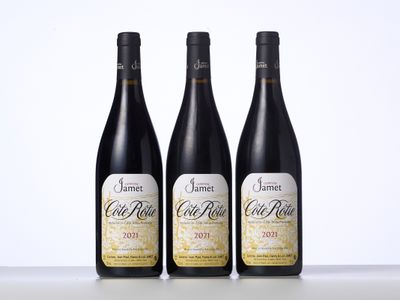 trois bouteilles de vin sont alignées sur une table