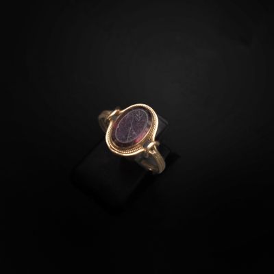 une bague en or avec une pierre violette au centre