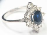 une bague ornée d'une pierre bleue entourée de diamants blancs
