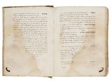 an old open book with writing on it sitting on a table
