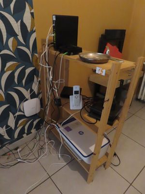 une table sur laquelle est posé un ordinateur portable, dans une pièce aux murs jaunes