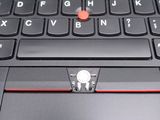 a close up of a laptop with a red button on the keyboard
