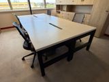 une table blanche avec une chaise noire dans une pièce vide