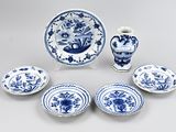 a group of blue and white plates and vases