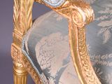 a gold and blue chair with a floral pattern on it