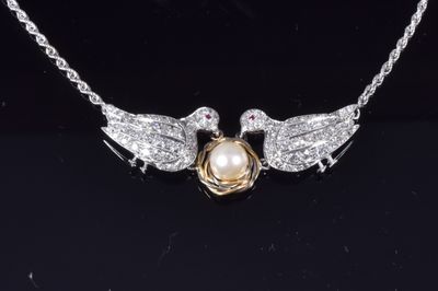 un collier Harry Potter orné d'un Vif d'or et de deux colombes blanches