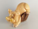 a figurine of a pig that is sitting on a tree stump