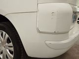 a close up of a white car with a denting on it