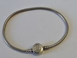 gros plan d'un bracelet en argent sur une surface blanche