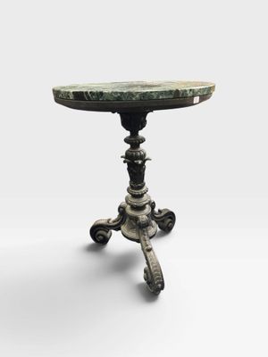 une petite table avec un plateau en marbre posé sur un piètement en métal