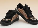 une paire de baskets noires à carreaux avec des semelles noires
