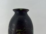 a vase with a painting on it sitting on a table