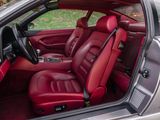 the interior of a silver car with red leather seats and a steering wheel